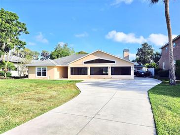 Charming single-story home featuring a well-manicured lawn and long concrete driveway at 2037 Lakeshore Dr, Mount Dora, FL 32757