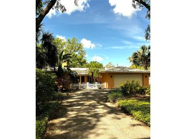 Charming single Gathering home with a white picket fence and lush landscaping and an attached garage at 2121 Suzanne Dr, Mount Dora, FL 32757
