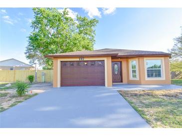 Charming single-story home featuring a brown garage door, manicured lawn, and freshly painted exterior at 316 Betty Ln, Mascotte, FL 34753