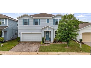 Charming two-story home with brick paver driveway, two car garage and beautifully landscaped front yard at 3235 Buoy Cir, Winter Garden, FL 34787