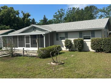 Charming one-story home featuring a screened-in porch and well-maintained front lawn at 32737 Vista Ave, Leesburg, FL 34788