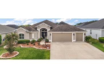Charming single-story home with a well-manicured front yard and a three car garage at 3354 Truluck Pl, Oxford, FL 34484