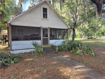 Charming home with a covered porch and mature landscaping offering a peaceful curb appeal at 350 Cassady St, Umatilla, FL 32784