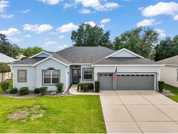 Charming single-story home with a well-manicured lawn, two-car garage, and welcoming facade at 3800 Woodleaf Ct, Leesburg, FL 34748