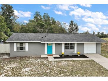 Charming single-story home featuring a bright blue front door and well-maintained landscaping at 425 Marion Oaks Dr, Ocala, FL 34473
