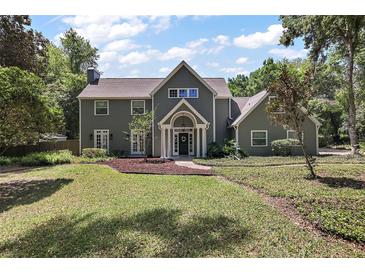 Charming two-story home featuring a well-manicured lawn, covered porch, and inviting front entrance at 4920 Sw 4Th Cir, Ocala, FL 34471