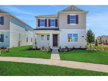 Charming two-story home with manicured lawn and inviting entrance, showcasing curb appeal at 5173 Waypointe Blvd, Apopka, FL 32712