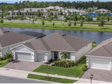 Stunning exterior view of home with lush landscaping and a serene water view at 6308 Mossy Oak Rd, St Cloud, FL 34771