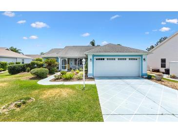 Charming single-story home with well-manicured lawn, two-car garage, and inviting front porch at 1306 Pedro Ct, The Villages, FL 32159