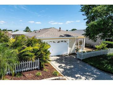 Charming single-story home featuring an attached garage, well-manicured landscaping, and a cozy screened lanai at 1667 Osprey Ave, The Villages, FL 32162