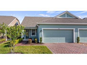 Charming single-story home with a two-car garage, brick driveway and well-manicured landscaping at 3256 Canna Lily Pl, Clermont, FL 34711