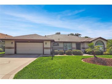 Charming single-story home featuring a well-maintained lawn and an attached two-car garage at 5408 Queen Victoria Dr, Leesburg, FL 34748