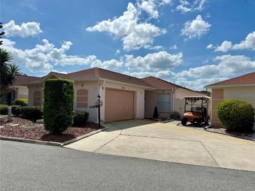 Charming single-story home featuring a two-car garage, mature landscaping, and a well-maintained lawn at 728 Ramirez Ave, The Villages, FL 32159