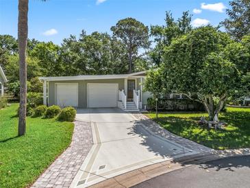 Charming single-story home with a well-manicured lawn, two-car garage, and inviting entryway at 1105 Del Toro Dr, The Villages, FL 32159