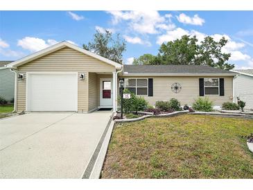Charming single-story home featuring a well-maintained lawn and attached one car garage at 1203 Zapata Pl, The Villages, FL 32159