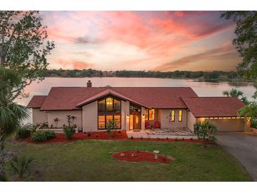 Scenic aerial view of a lakefront property, with beautiful landscaping, waterfront access, and charming curb appeal at 3011 Lake Woodward Dr, Eustis, FL 32726