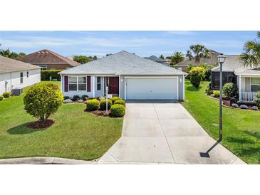 Charming single-story home with well-maintained landscaping and an inviting front yard at 3203 Islawild Way, The Villages, FL 32163
