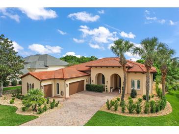 Stunning Mediterranean-style home with a red tile roof, arched entryways, and a meticulously landscaped front yard at 38716 Oak Place Ct, Lady Lake, FL 32159