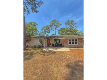 Charming single story home with stone accents, manicured lawn, and welcoming front porch area at 802 Haselton St, Eustis, FL 32726