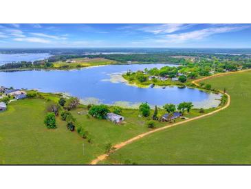 Aerial view of a lakeside home with a sprawling lawn and beautiful water access at 9510 Suggs Rd, Clermont, FL 34711