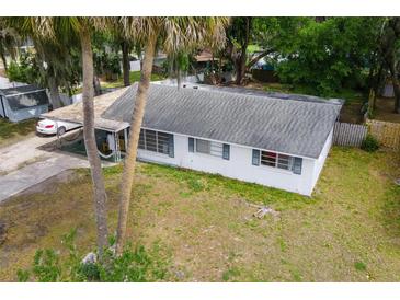 Charming single story home with carport and white exterior and blue shutters at 1406 Spartan Ave, Leesburg, FL 34748