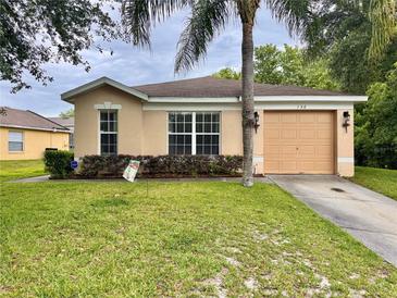 Charming single-story home with a well-manicured lawn and mature landscaping at 156 Ridgebrook Ct, Davenport, FL 33896