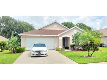 Charming single-story home featuring a well-manicured lawn and attached two-car garage at 15702 Bay Vista Dr, Clermont, FL 34714