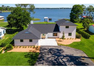 Stunning waterfront home featuring a new roof and a circular driveway leading to its grand entrance at 16047 E Shirley Shores Rd, Tavares, FL 32778