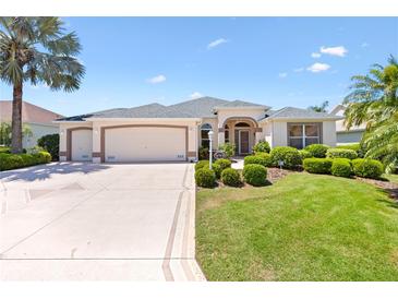 Well-maintained single-story home with manicured lawn, mature palms, and a triple-car garage at 1716 Bugle Ter, The Villages, FL 32162