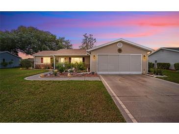 Charming single-story home featuring a manicured lawn and an attached two-car garage at 17806 Se 97Th Ct, Summerfield, FL 34491