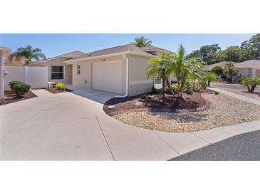 Stunning exterior shot showcasing the manicured lawn, two-car garage, and inviting facade of this lovely home at 2026 Altamonte Way, The Villages, FL 32162