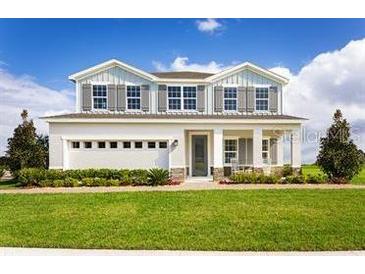 Beautiful two-story home featuring manicured lawn and inviting front porch at 2048 Airedale Way, Lake Alfred, FL 33850