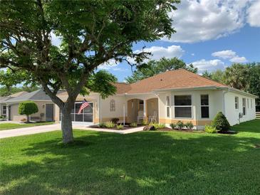 Charming single-story home featuring a well-manicured lawn and inviting front porch seating at 2256 Margarita Dr, The Villages, FL 32159