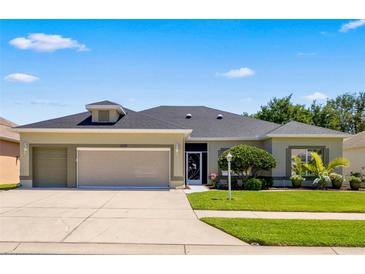 Charming single-story home with a well-manicured lawn and a two-car garage at 25524 Maurepas Ln, Leesburg, FL 34748