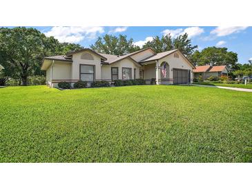 Charming single-story home with a well-manicured lawn and an inviting exterior at 27022 Racquet Cir, Leesburg, FL 34748