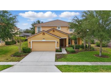 Charming two-story home with manicured lawn, beautiful landscaping, and neutral color palette at 4147 Oaktree Dr, Davenport, FL 33837