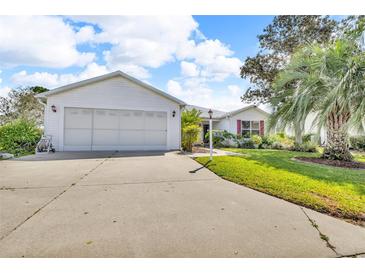 Charming single-story home with a well-manicured lawn, a two-car garage, and vibrant landscaping at 767 Barbados Pl, The Villages, FL 32162