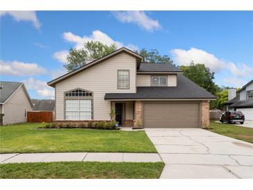 Charming two-story home featuring a well-manicured lawn and an attached two-car garage at 1413 Silverthorn Dr, Orlando, FL 32825