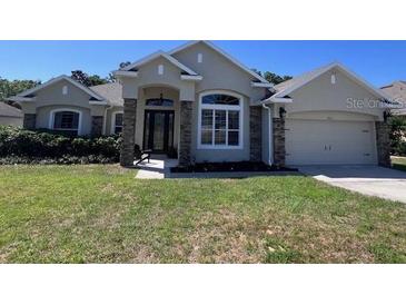 Charming single-story home featuring a well-manicured lawn and attached two car garage at 326 Crystal Pond Ave, Deland, FL 32720