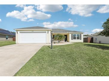 Charming single-story home features a well-manicured lawn and attached two car garage at 3329 Boyd Cir, Oxford, FL 34484