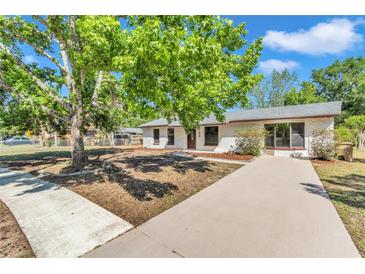 Charming one-story home with a well-manicured lawn, complemented by mature trees and a spacious driveway at 3415 Sail Fish Ave, Fruitland Park, FL 34731