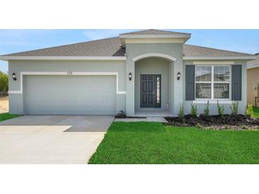 Charming single-story home with a well-manicured lawn, a two-car garage, and a welcoming front entrance at 4118 Penelope Ave, Lake Wales, FL 33859