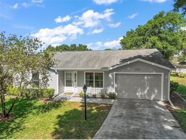 Charming single-story home with a well-manicured lawn, attached garage, and inviting front entrance at 4553 Belle Grv, Leesburg, FL 34748