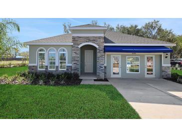 Beautiful single-story home with stone accents, arched windows, and a well-manicured lawn at 5039 Abigail Dr, Lake Wales, FL 33859