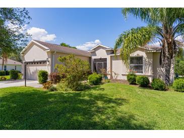 Inviting single-story home with a well-manicured lawn and mature landscaping adding to its curb appeal at 5941 Sage Leaf Pl, Leesburg, FL 34748