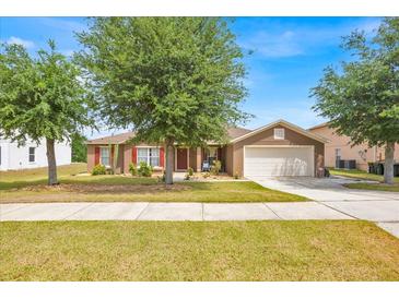 Charming single-Gathering home featuring a well-maintained lawn, a two-car garage, and complemented by mature trees at 597 Skyridge Rd, Clermont, FL 34711