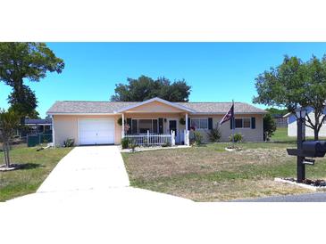 Charming single-story home featuring an attached garage, front porch with white picket fence, and well-maintained landscaping at 11250 Sw 78Th Ct, Ocala, FL 34476