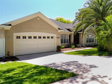 Charming single-story home boasts a well-maintained lawn, lush landscaping and an attached two car garage at 13319 Via Roma Cir, Clermont, FL 34711