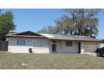 Single story home with front yard featuring an asphalt driveway and gray, weathered roof at 1400 Kirby St, Ocoee, FL 34761