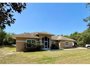 Inviting single-story home featuring a screened front entry and manicured lawn at 31728 Nutmeg Ave, Eustis, FL 32736